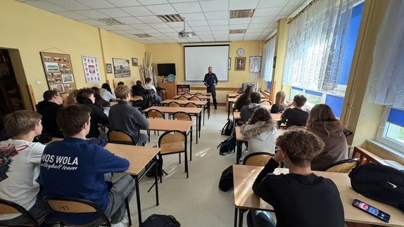 Policjant stoi przed uczniami.