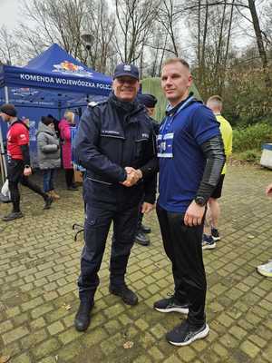 Policjanci podają sobie rękę.