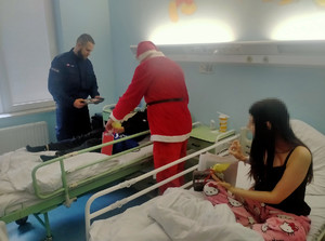 Policjant i Mikołaj rozdają prezenty.