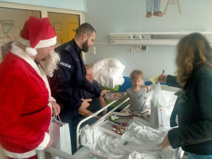Policjant i Mikołaj rozdają prezenty.