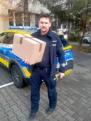Policjant trzyma pudełko.