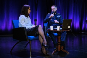 Policjant mówi do mikrofonu.