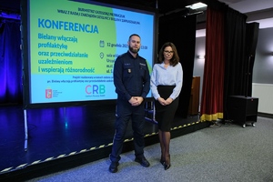 Policjant stoi z kobietą.