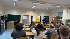 Policjant stoi przed nauczycielami.