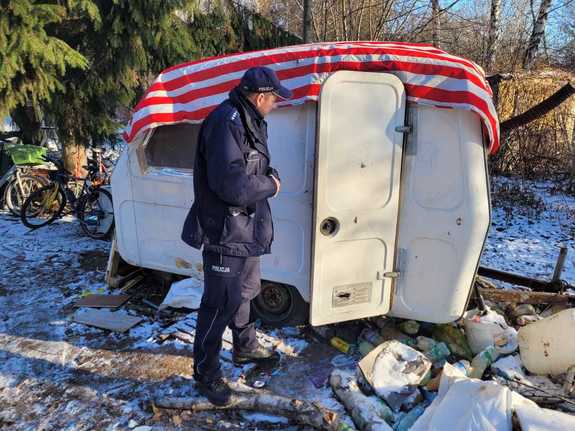 Policjant stoi przy przyczepie.