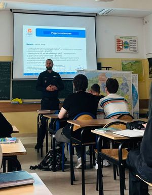 Policjant stoi przed uczniami.