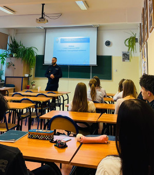 Policjant stoi przed uczniami.