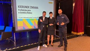 Policjant z innymi osobami na konferencji.