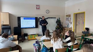 Policjant stoi przed uczniami.