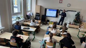 Policjant stoi przed uczniami.