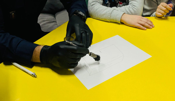 Policjant wykonuje odbitki linii papilarnych.