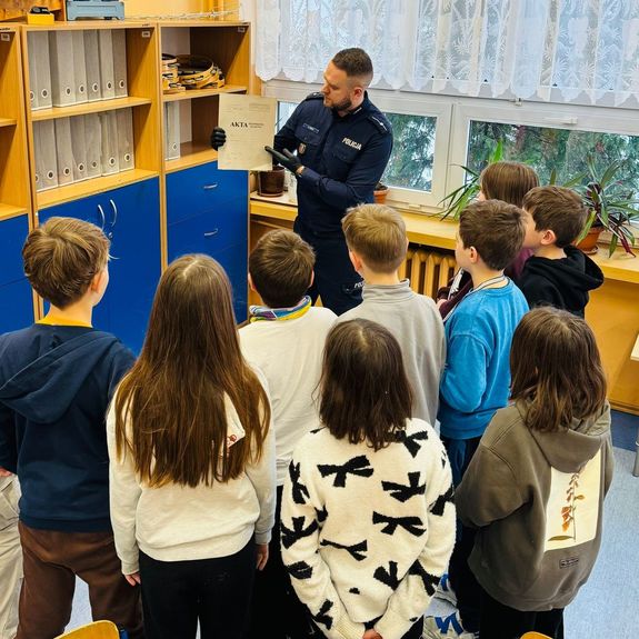 Policjant pokazuje akta.