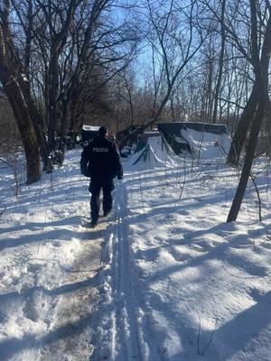 Policjant idzie do namiotu.