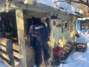 Policjant zagląda przez okno.