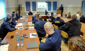 Policjanci siedzą przy stole.