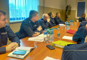 Policjanci siedzą przy stole.