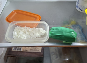 Skrystalizowana substancja w plastikowym pudełku.