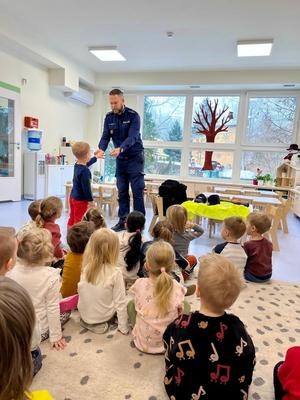 Policjant stoi przed dziećmi.