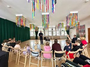 Policjant stoi przed dziećmi.