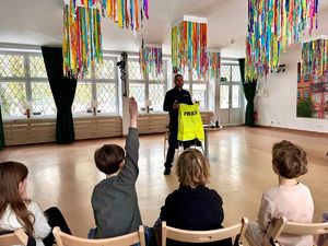 Policjant trzyma kamizelkę.