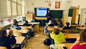 Policjant stoi przed uczniami.