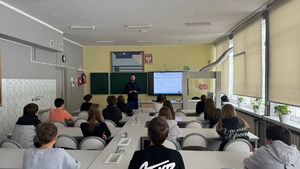 Policjant stoi przed uczniami.