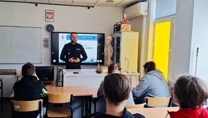 Policjant stoi przed uczniami.