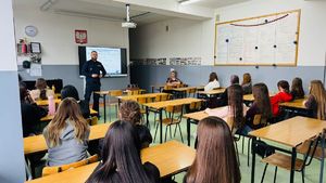 Policjant stoi przed uczniami.