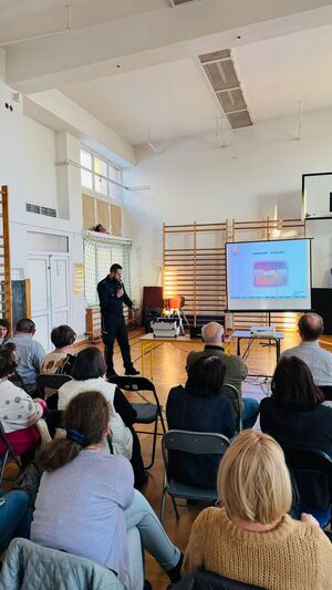 Policjant stoi przed nauczycielami.