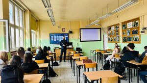 Policjant stoi przed uczniami.