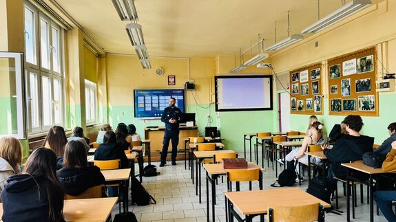 Policjant stoi przed uczniami.