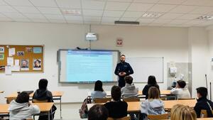 Policjant stoi przed uczniami.