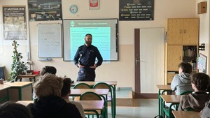 Policjant stoi przed uczniami.