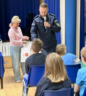 Policjant rozmawia z dziećmi.