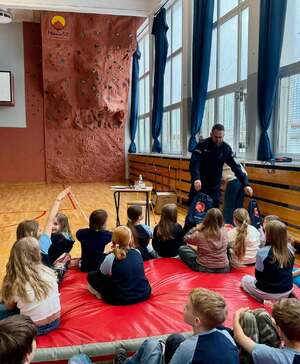 Policjant stoi przed dziećmi.