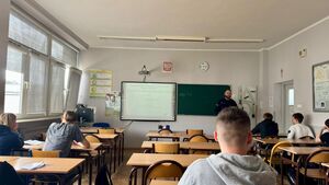 Policjant stoi przed tablicą.