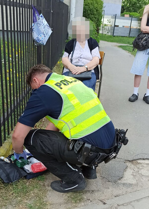 Policjant kuca przed kobietą.