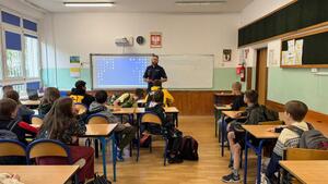 Policjant stoi przed uczniami.