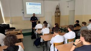 Policjant stoi przed uczniami.