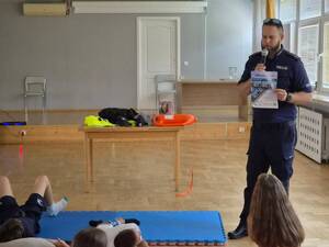 Policjant stoi przed uczniami.