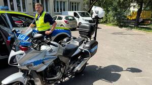 Policjant stoi przy motocyklu.