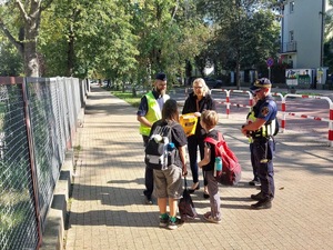 Policjant i uczniowie przed szkoła