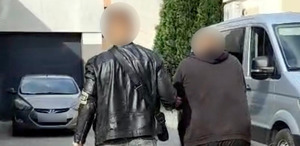 Policjant prowadzi zatrzymanego.