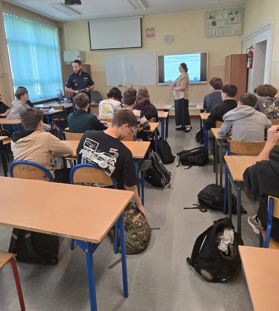 Policjant stoi przed uczniami.