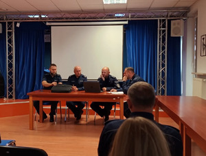 Policjanci siedzą za stołem.