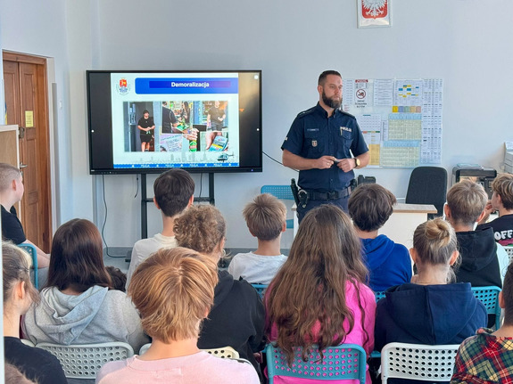 Policjant stoi przed uczniami.