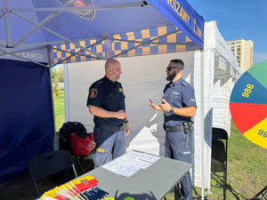 Policjant rozmawia ze strażnikiem.