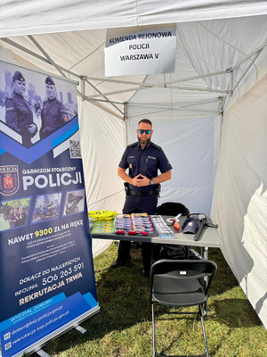 Policjant stoi przy stoisku.