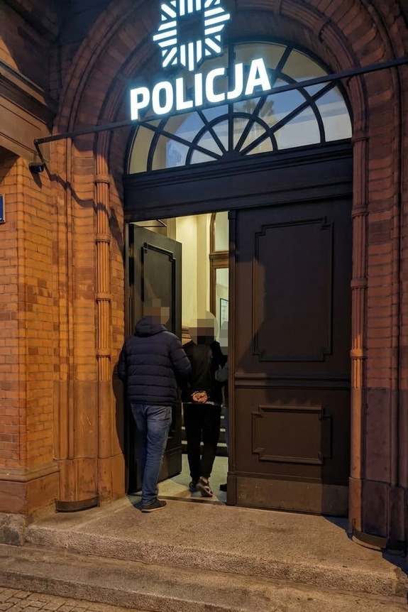 Policjanci prowadzą zatrzymanego.